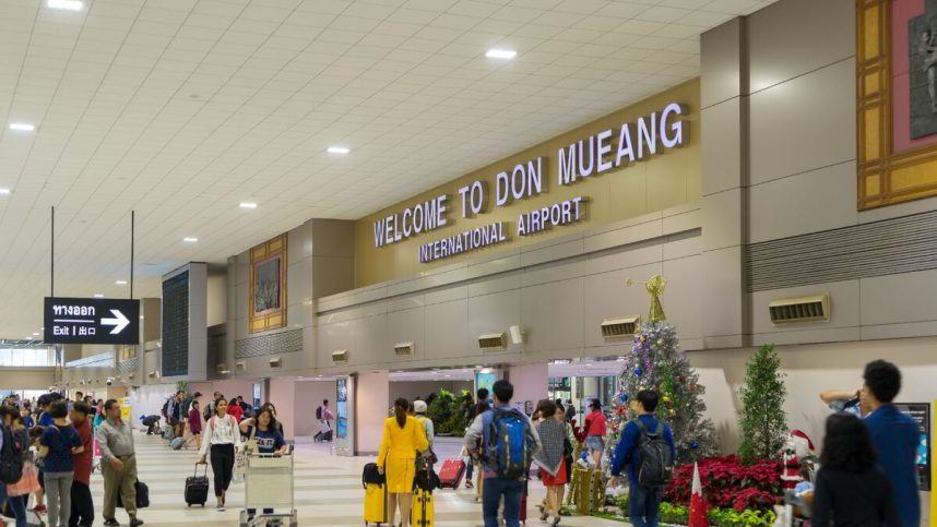 Travelers walk through the Don Mueang International Airport in Bangkok, Thailand